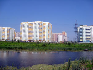 Lago y casas nuevas en la calle Brusílova.